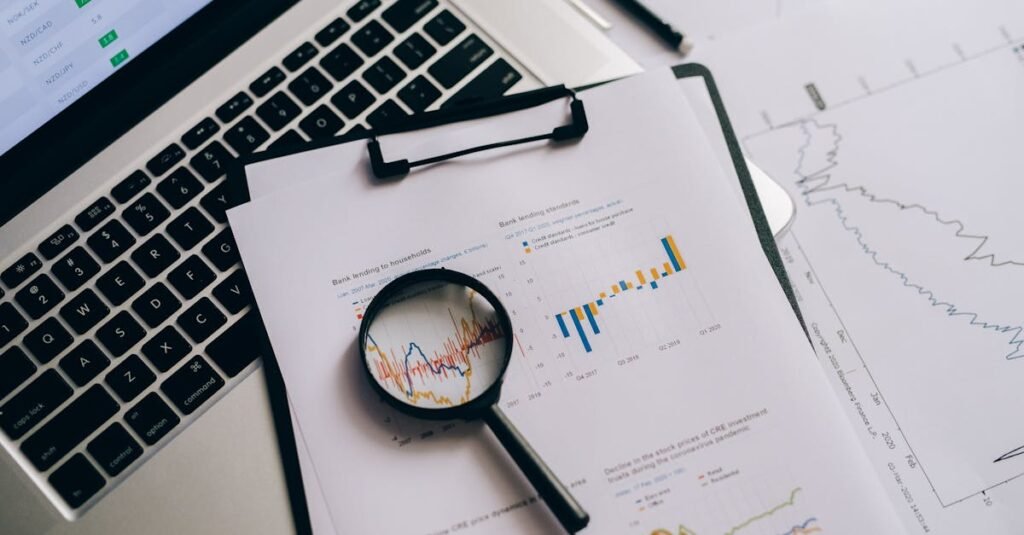 Overhead view of financial charts, laptop, and magnifying glass, ideal for business analysis themes.